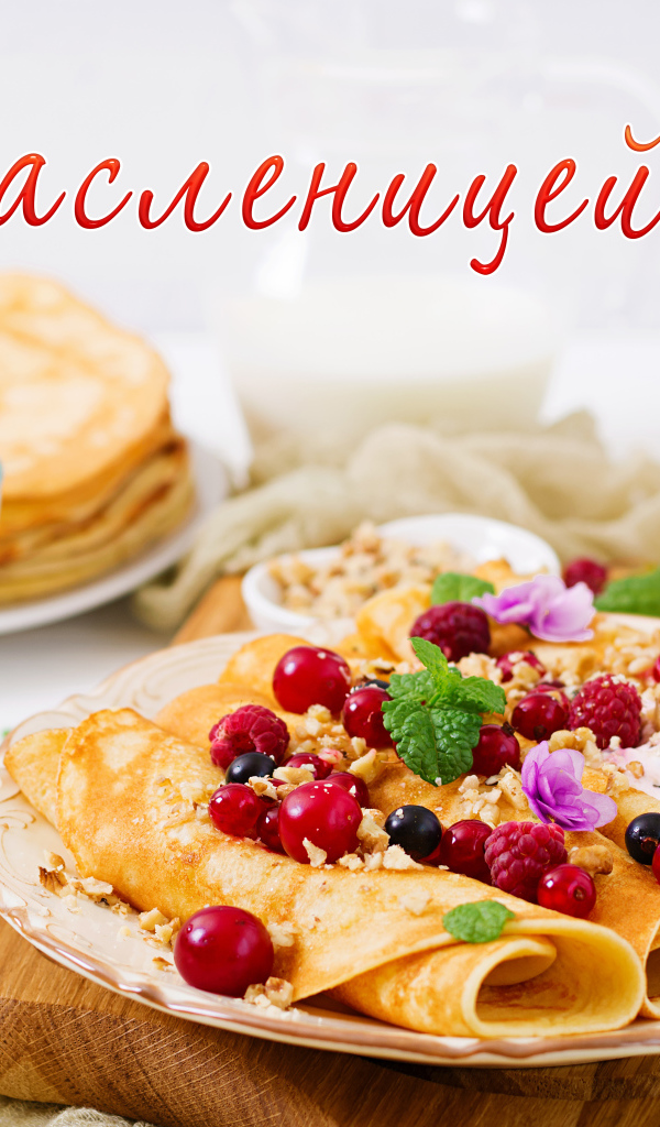 Тонкие блины на тарелке с ягодами на праздник Масленица