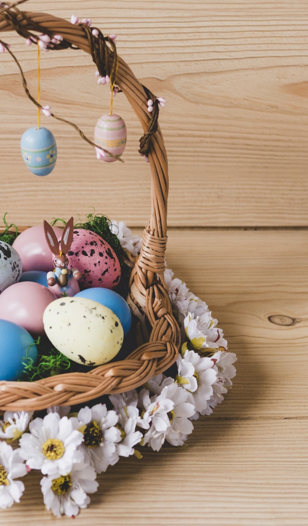 Корзинка с пасхальными яйцами украшена цветами