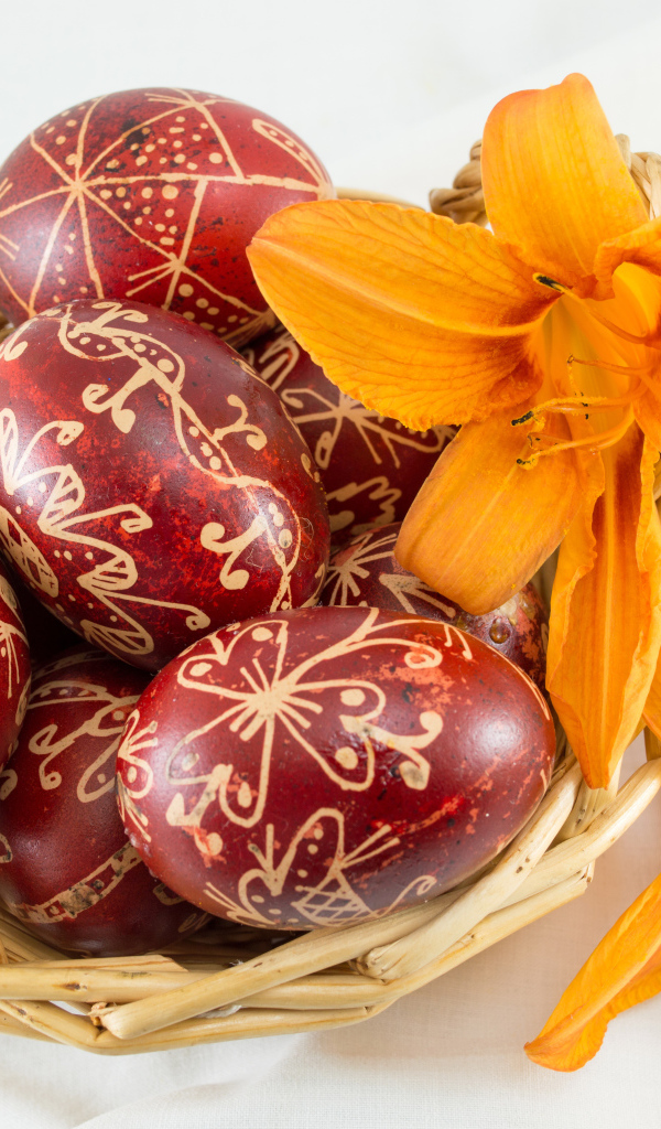 Красивые пасхальные яйца с цветами лилии в корзине