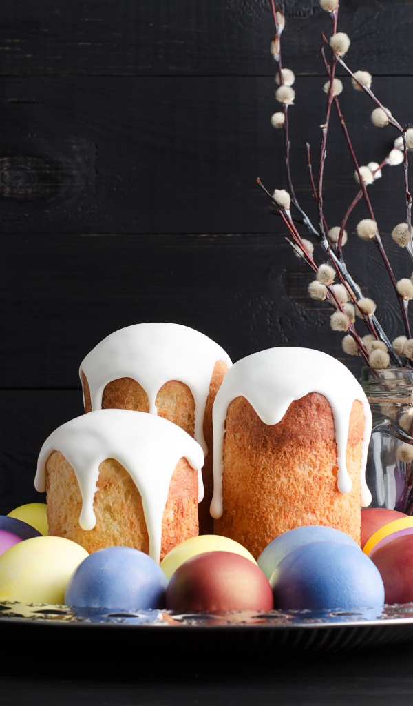 Вкусные куличи на подносе с яйцами и ветками вербы на Пасху