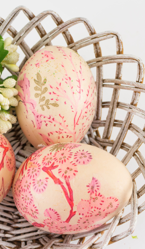 Яйца с рисунком в корзине с цветами на Пасху
