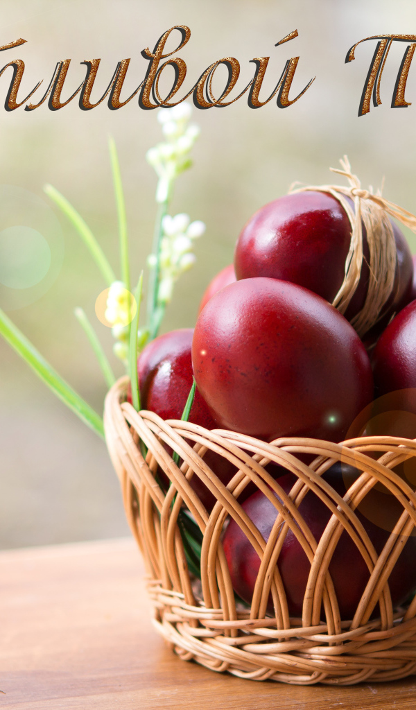 Красные крашеные яйца в корзине, открытка с надписью Счастливой Пасхи