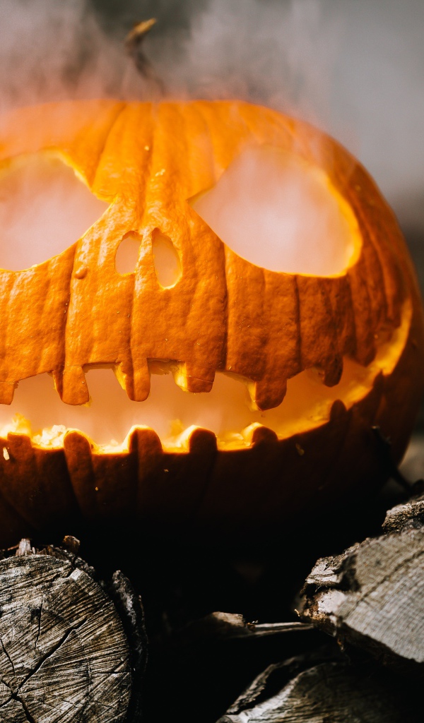Желтая тыква с дымом на дровах на Хэллоуин