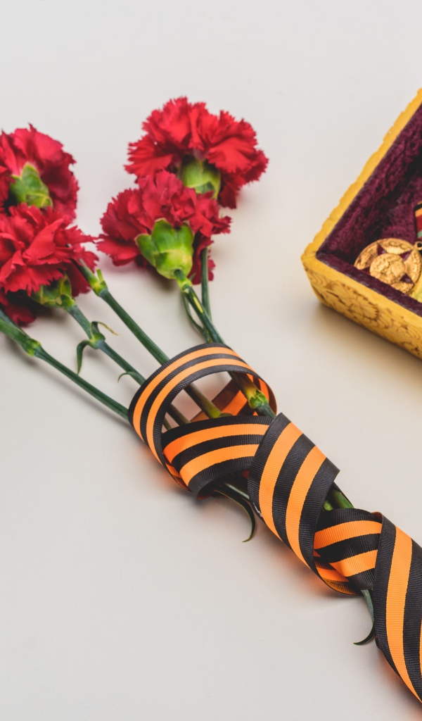 Букет гвоздик с георгиевской лентой и наградами на День Победы 9 мая