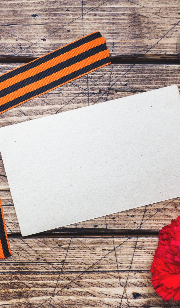 Красные гвоздики, георгиевская лента и свечи на столе, шаблон для открытки на 9 мая День победы