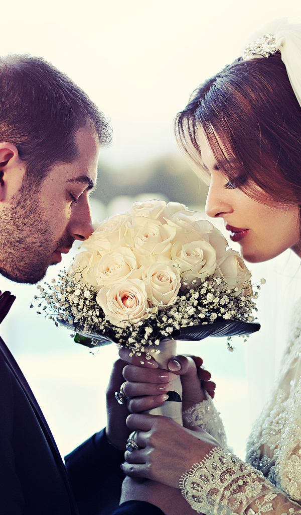 Жених и невеста с букетом белых роз 