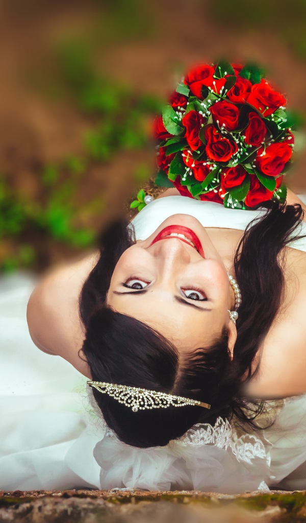 Улыбающаяся девушка невеста с букетом красных роз