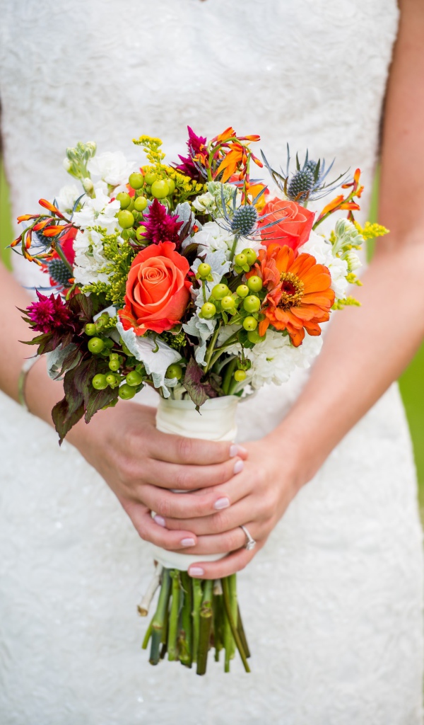 Букет невесты в руках у девушки в белом свадебном платье