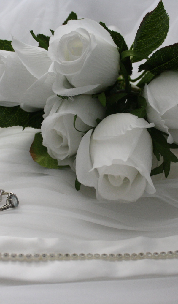 Белые бутоньерки с кольцами на белом покрывале 