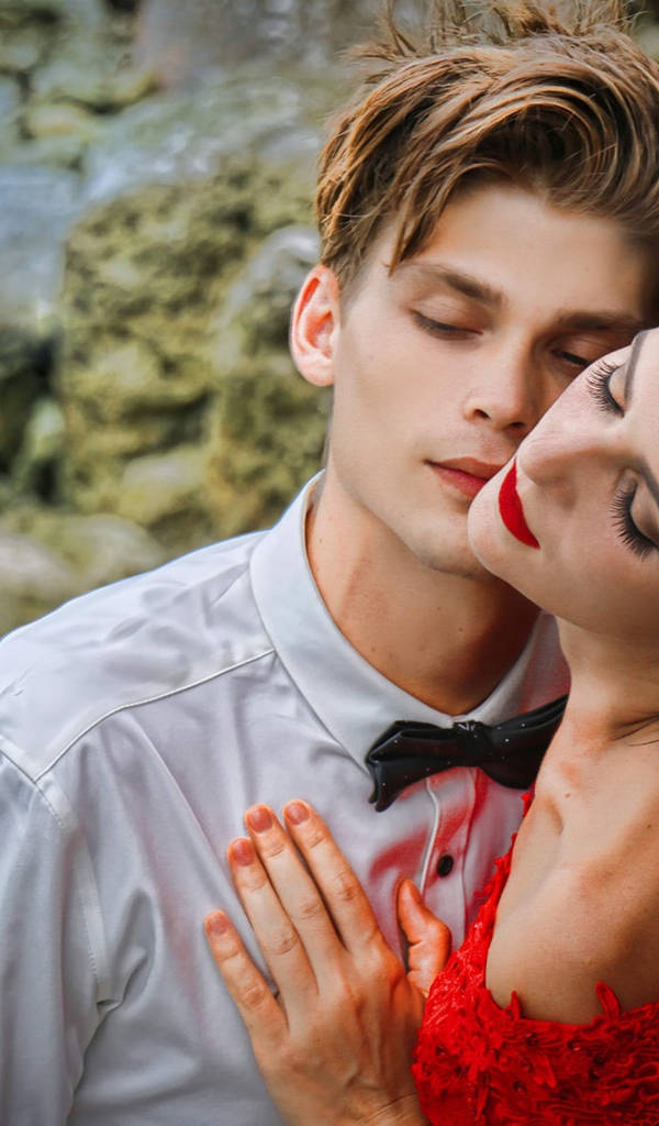 Красивая влюбленная пара стоит у камней