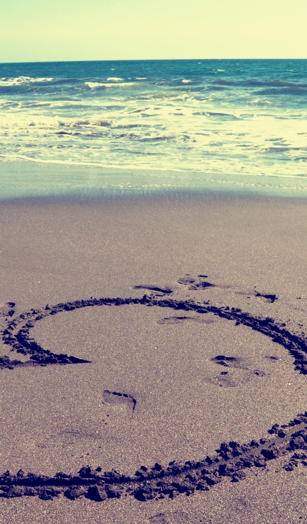 Большое сердце на мокром песке на пляже