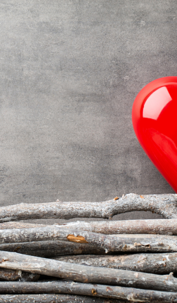 Большое красное сердце на сером фоне с деревянными прутьями