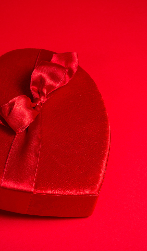 Большое красное сердце с бантом на красном фоне