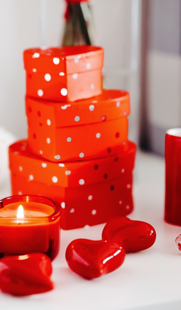 Чашка кофе на столе с подарками, зажженными свечами и сердечками