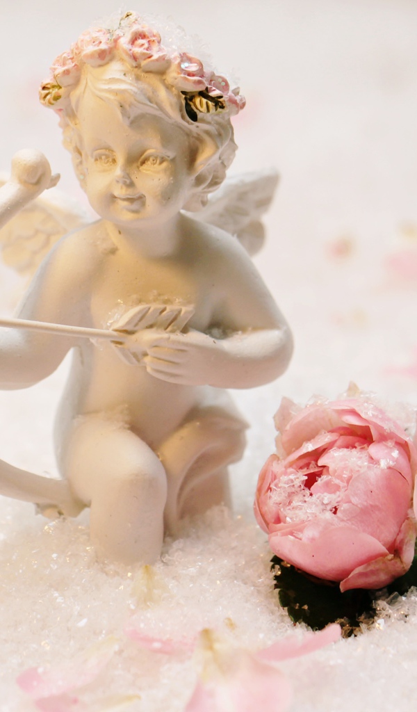Статуэтка купидона с розой на снегу