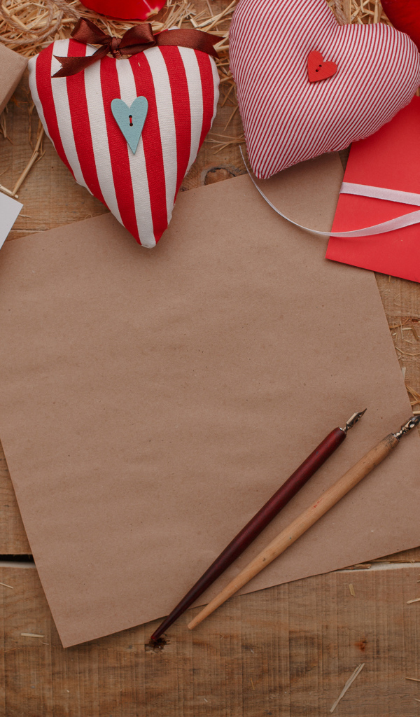 Сердечки из ткани на столе с бумагой и подарками 