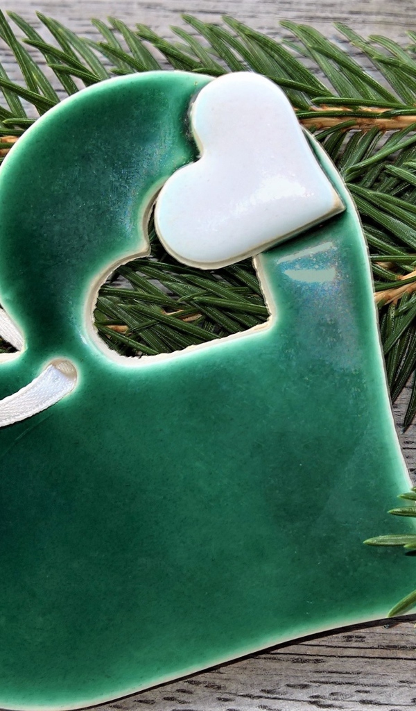 Зеленое сердце с еловой веткой на столе 