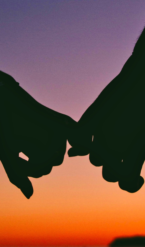 Руки влюбленной пары на закате солнца 