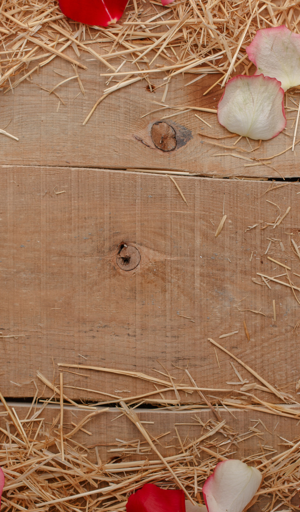 Сено и лепестки роз на деревянном столе 