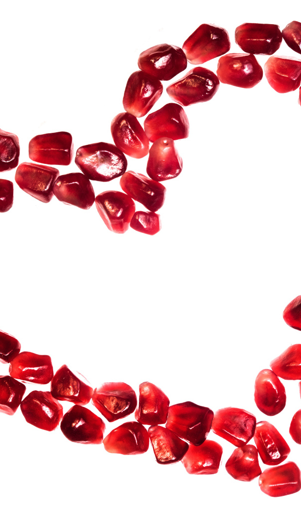 Сердце из гранатовых зерен на белом фоне