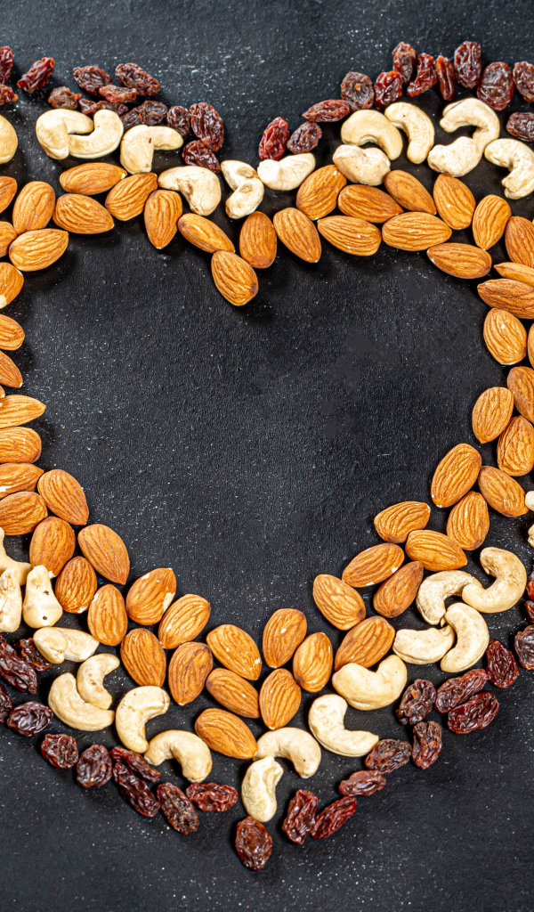 Сердце из орехов и изюма на сером фоне