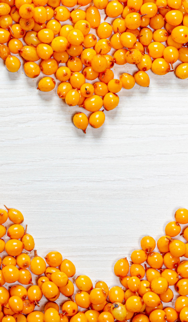 Сердце из ягод облепихи на столе 