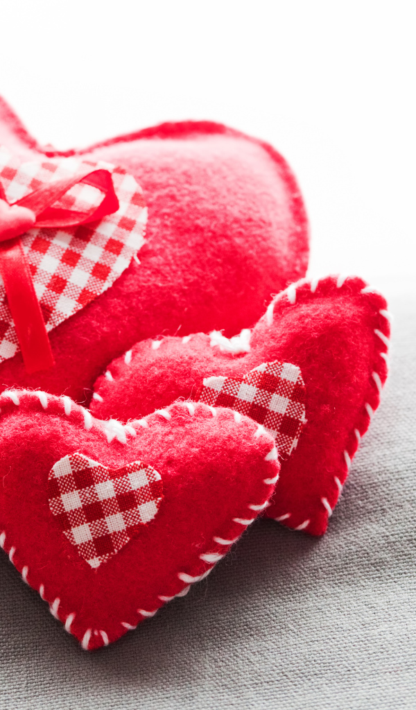 Сердечки из ткани лежат на серой поверхности 