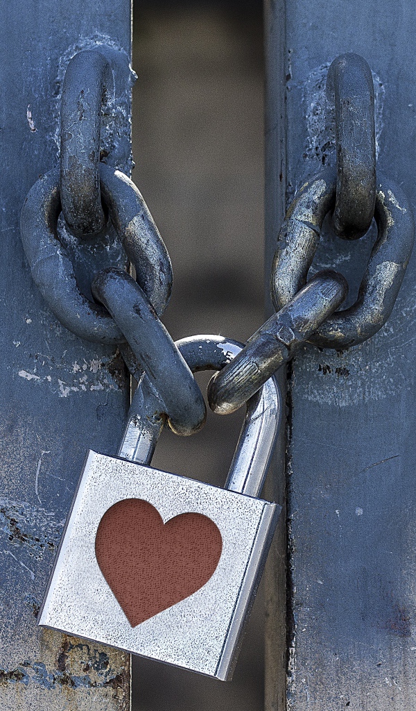 Железный замок с сердцем висит на цепи 