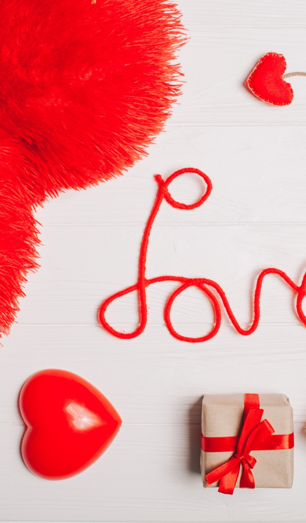 Большая подушка в форме сердца на столе с подарками 