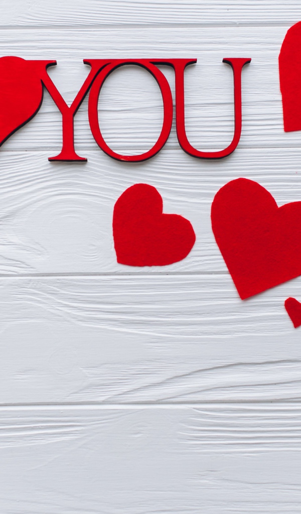 Надпись Я тебя люблю с красными сердечками на столе
