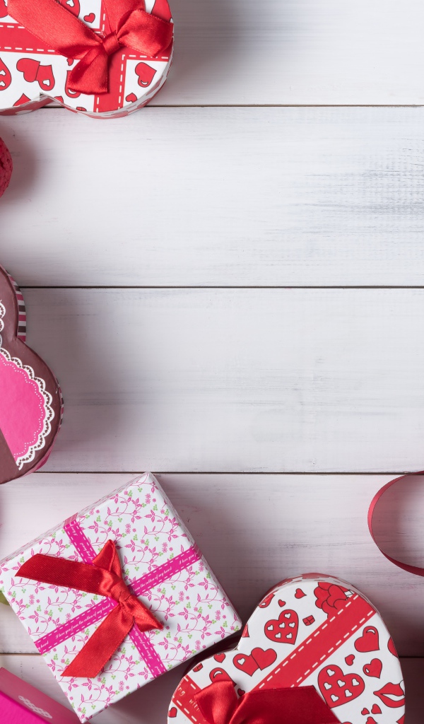 Много подарочных коробок в форме сердца на сером столе 