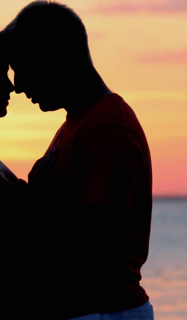 Влюбленная пара на фоне моря в сумерках 