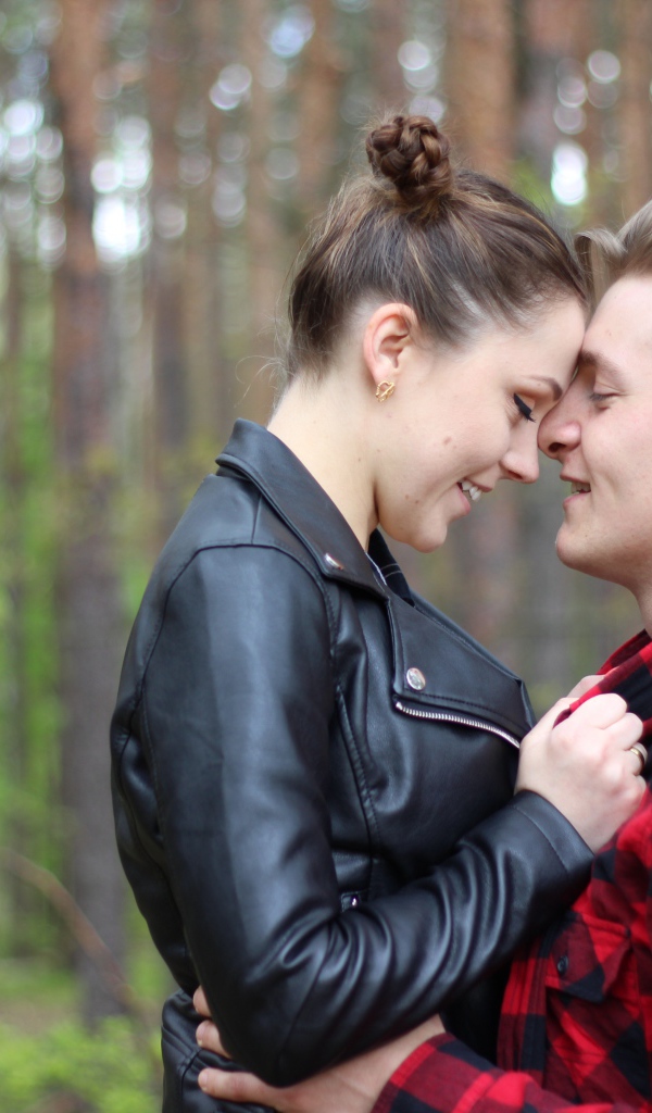 Влюбленная пара стоит в лесу 