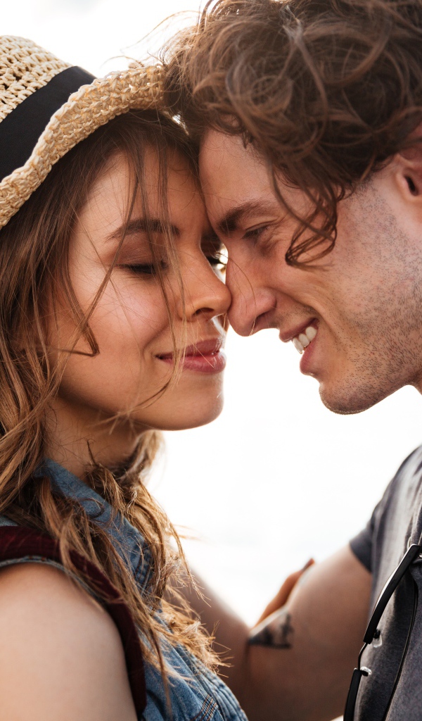 Влюбленная пара стоит на фоне моря 