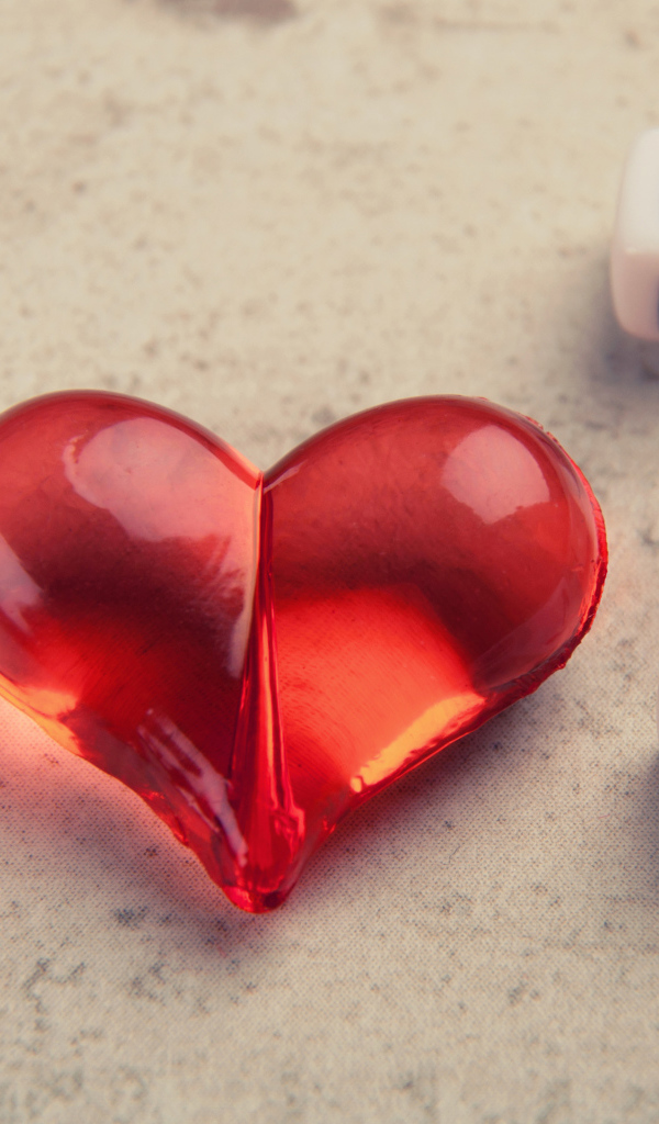 Красное стеклянное сердце на столе с кубиками