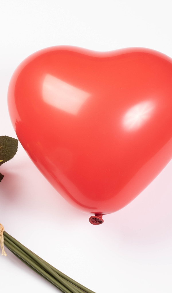 Красный шарик в форме сердца с букетом роз на белом фоне