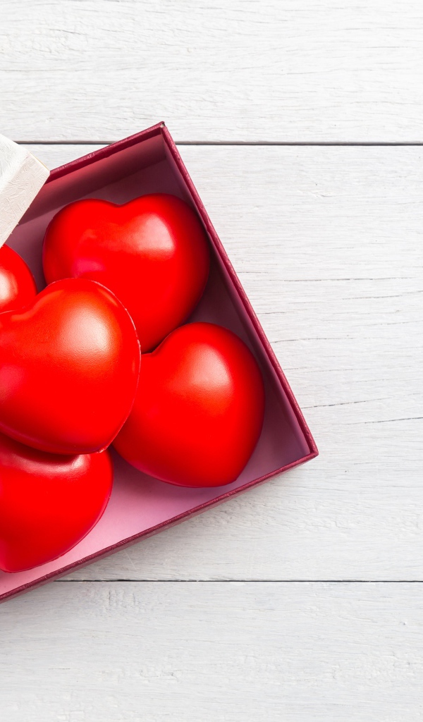 Красные сердечки в коробке на сером фоне