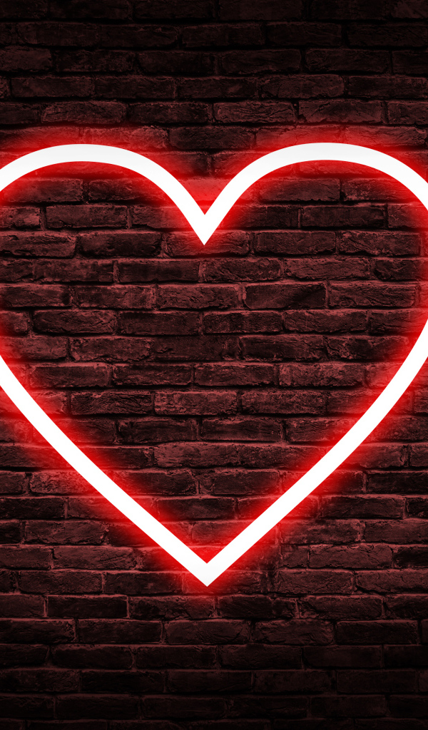 Красное неоновое сердце на кирпичной стене 