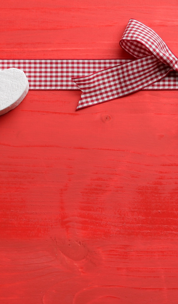 Два сердечка с бантом на красном фоне