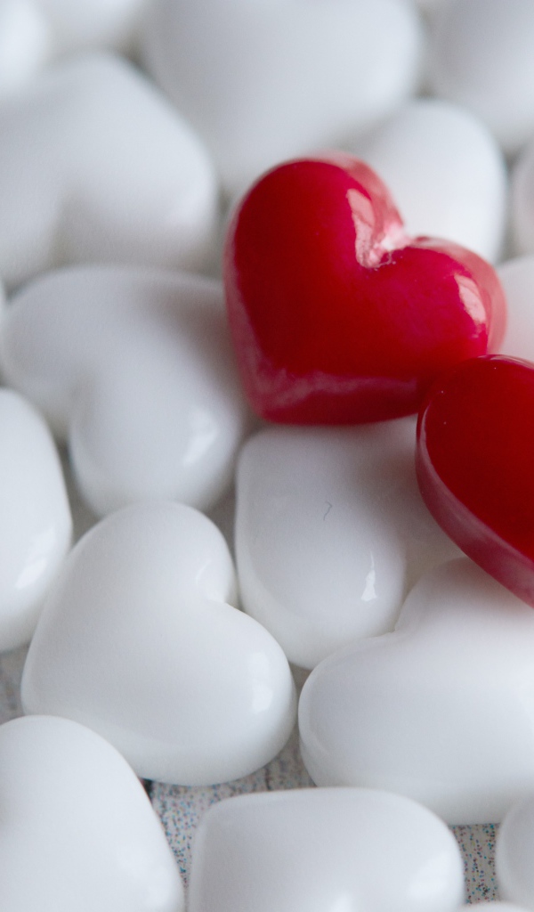 Два красных сердца лежат на белых 