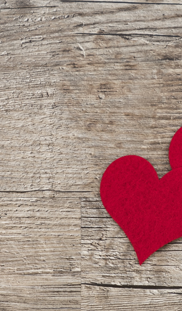 Два красных сердца на деревянном столе