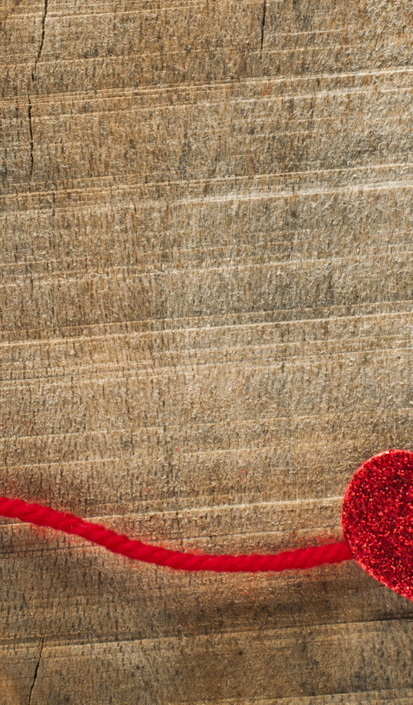 Два красных сердца со шнурком на деревянном фоне