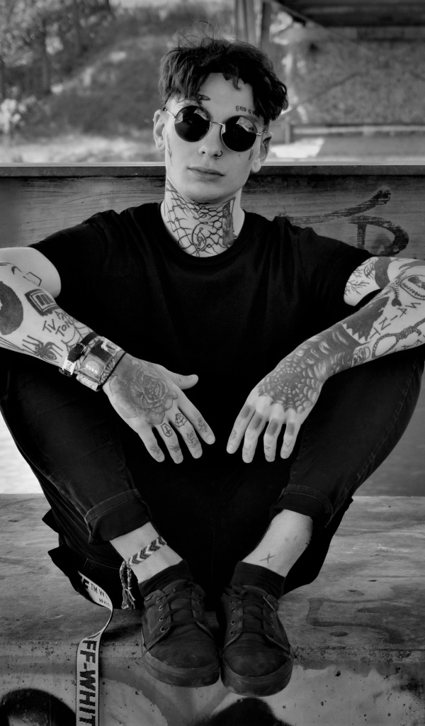 Мужчина в черных очках с татуировками на теле 