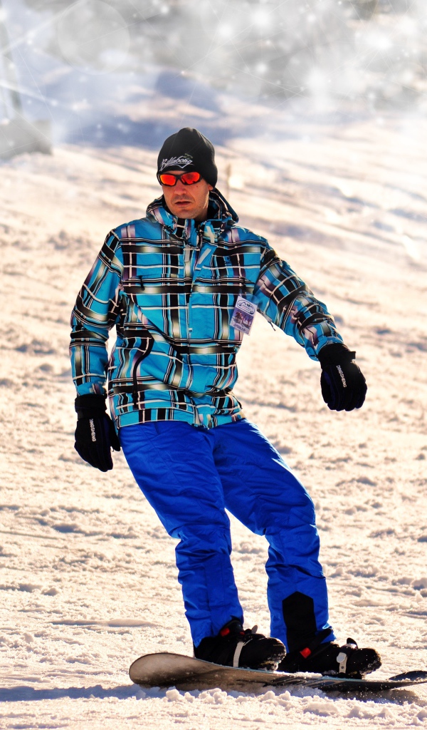 Мужчина сноубордист съезжает с горы 