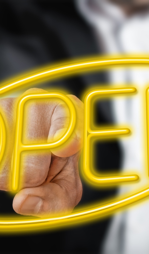 A man touches a yellow neon inscription Open with his finger