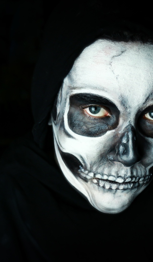 Мужчина в черном наряде с гримом на лице на Хэллоуин