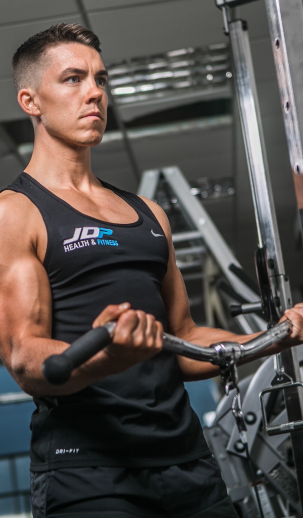 Накаченный мужчина занимается на тренажере в спортзале