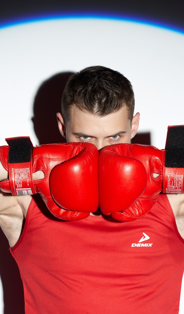 Male boxer with red gloves in the spotlight