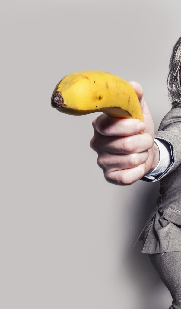 Мужчина в костюме защищается бананом