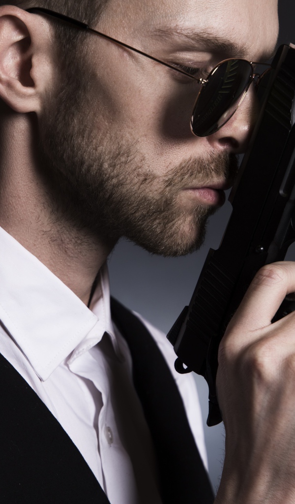 Мужчина в очках с пистолетом в руке